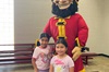 Captain Vic and two children holding new backpacks