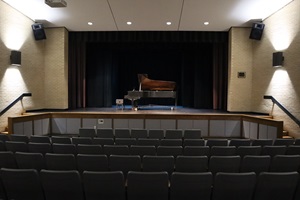 A concert piano on the interior stage of Johnson Symposium