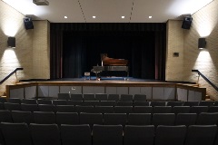 A concert piano on the interior stage of Johnson Symposium