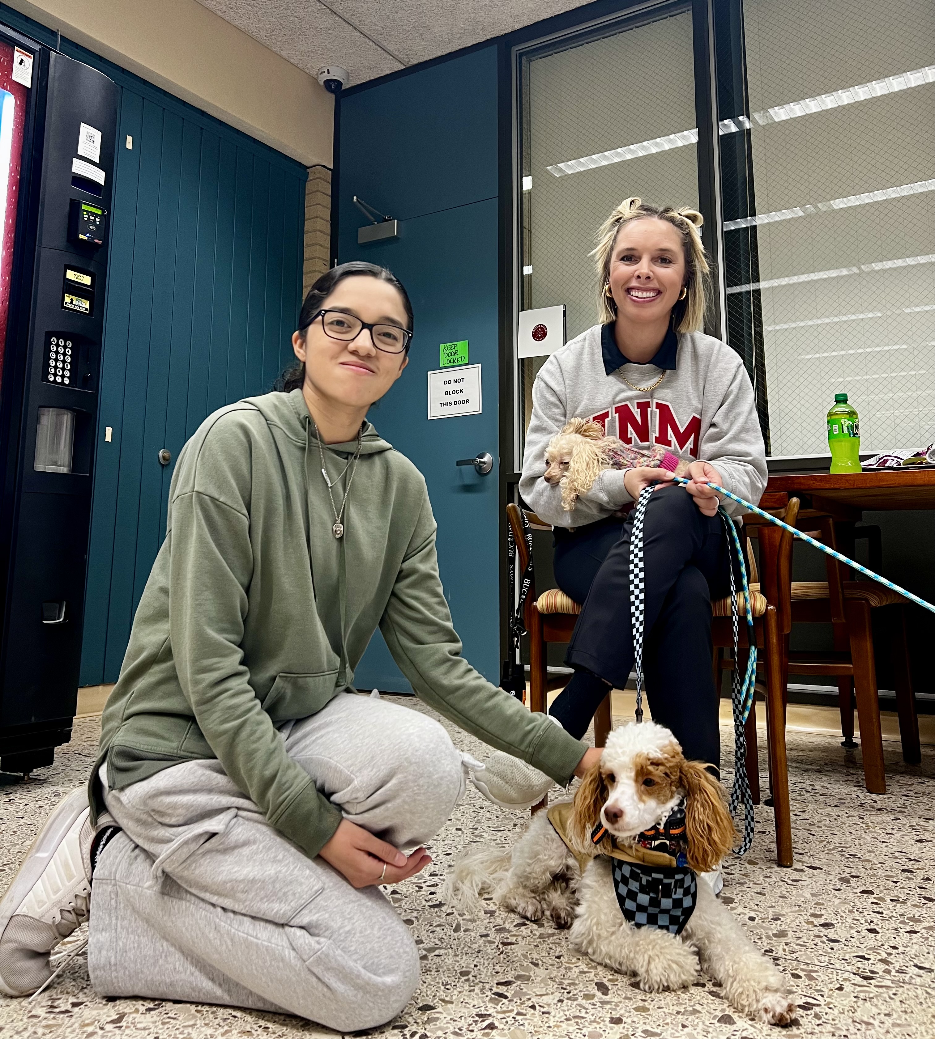 A VC student poses with a staff member and her poodles
