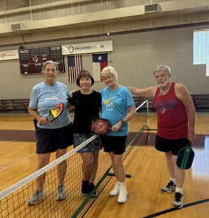 ALL Pickleball players smile with paddles in the VC gym