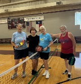 ALL Pickleball players smile with paddles in the VC gym