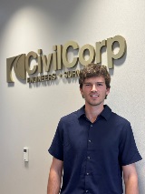 Cy Richter smiles in front of the CivilCorp logo at the headquarters