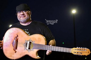 Isaac De Los Santos poses with his guitar on stage