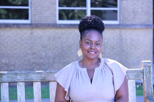 La Shaundrea Harris sitting on a bench outdoors smiling
