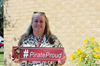 Michelle holds the #PirateProud sign outside on a sunny day