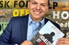 Roy Juarez Jr holds a copy of his book