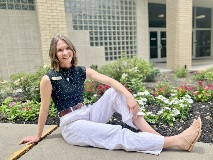 Sophia Kameitjo smiles by a bed of flowers