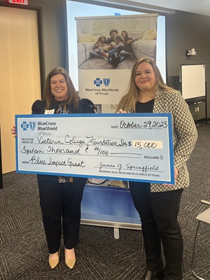 Victoria College rep accepts a grant check